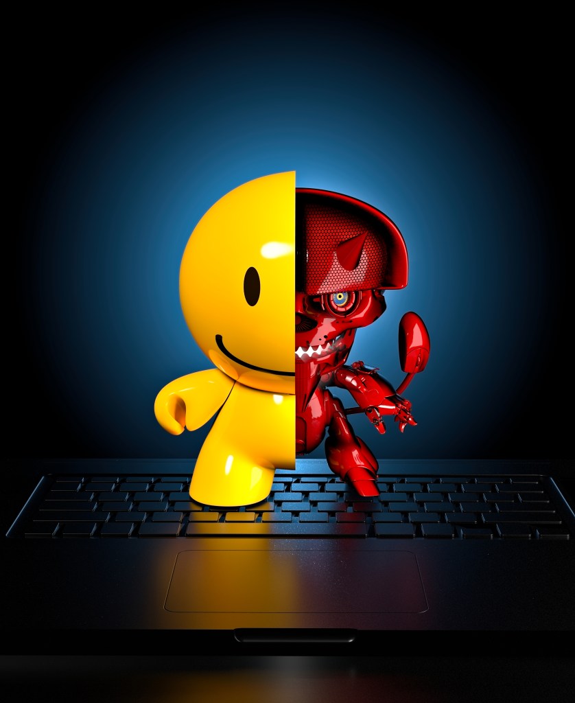 A split illustration featuring a yellow smiley face on one side and a red robotic figure with sharp teeth on the other, emerging from a laptop keyboard against a dark blue background.